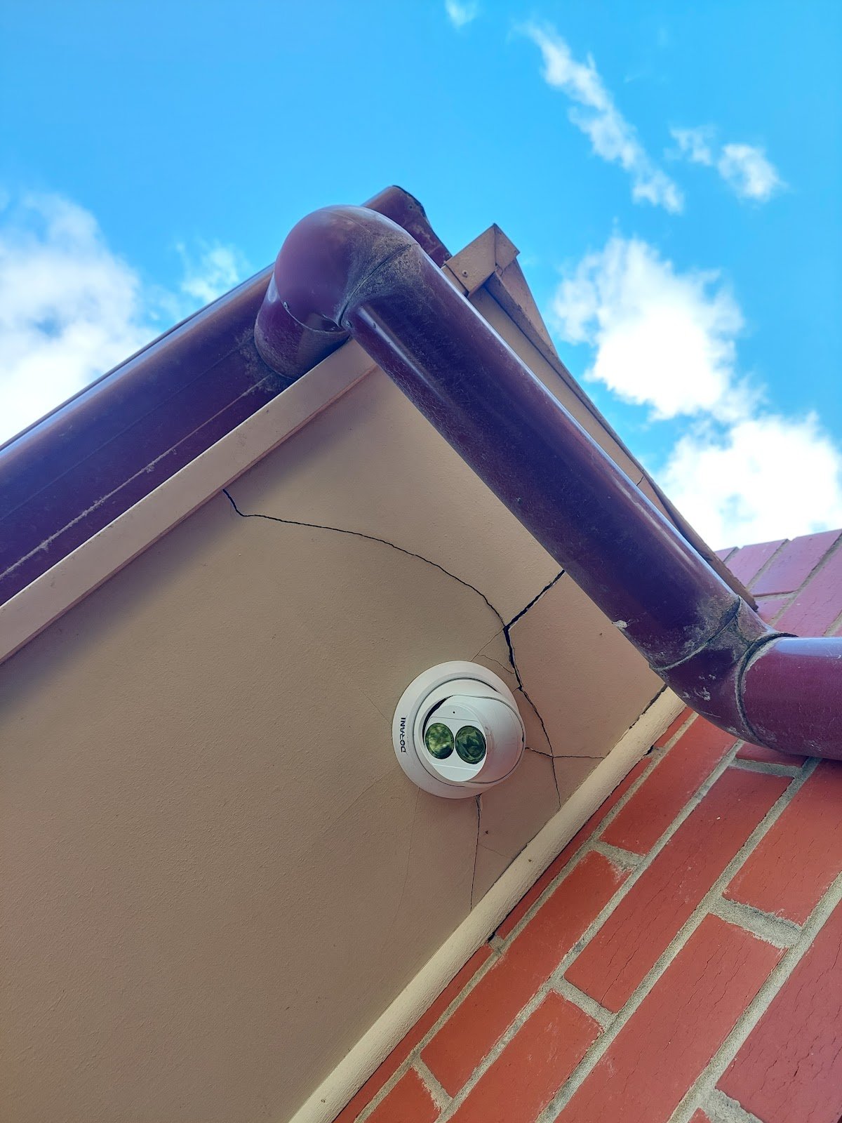Cracked eave lining at the corner of a roof before repair