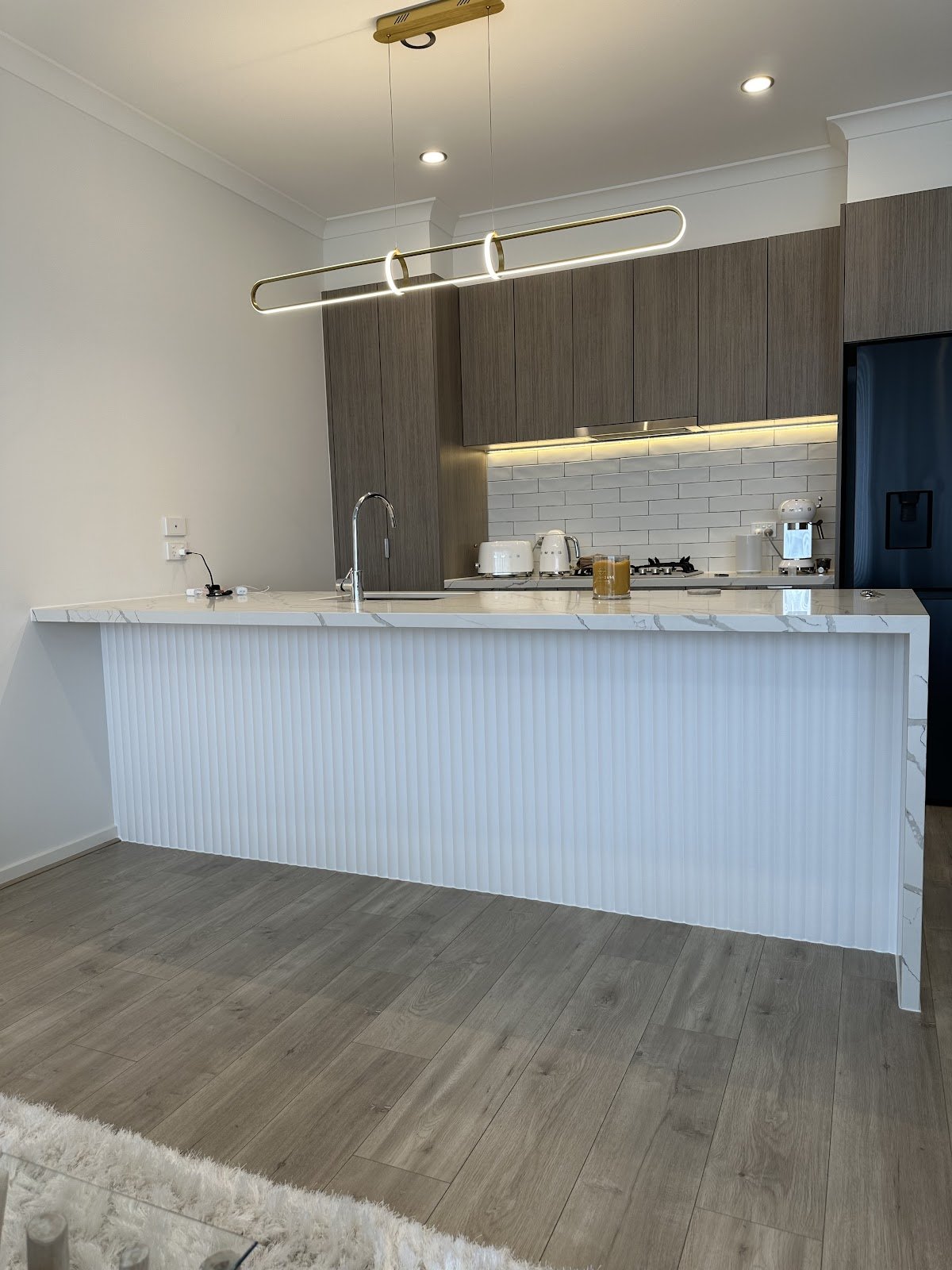 Kitchen island with white fluted feature panelling and marble benchtop