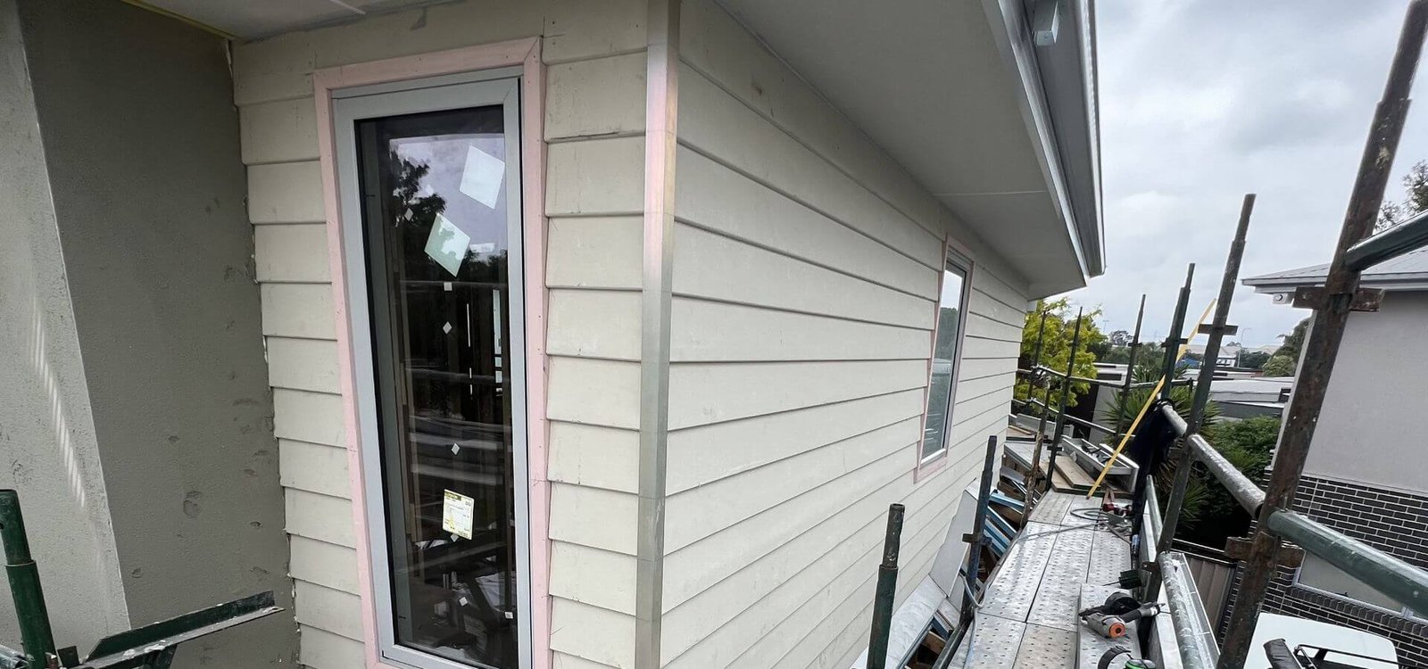 Weatherboard cladding being installed on an upper storey extension
