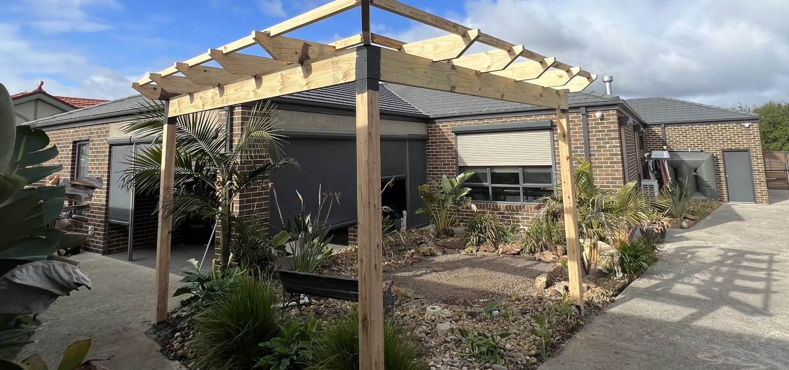 Timber pergola frame built over a landscaped garden courtyard